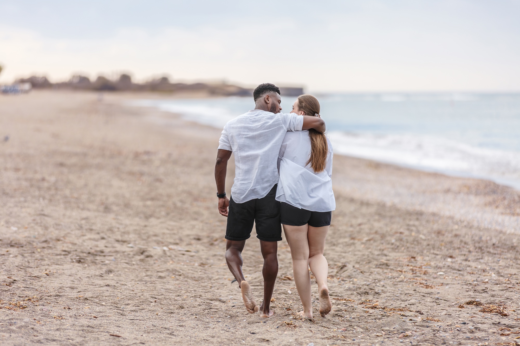 A bride and groom stroll along the beautiful Zapillo beach in Almeria, Spain