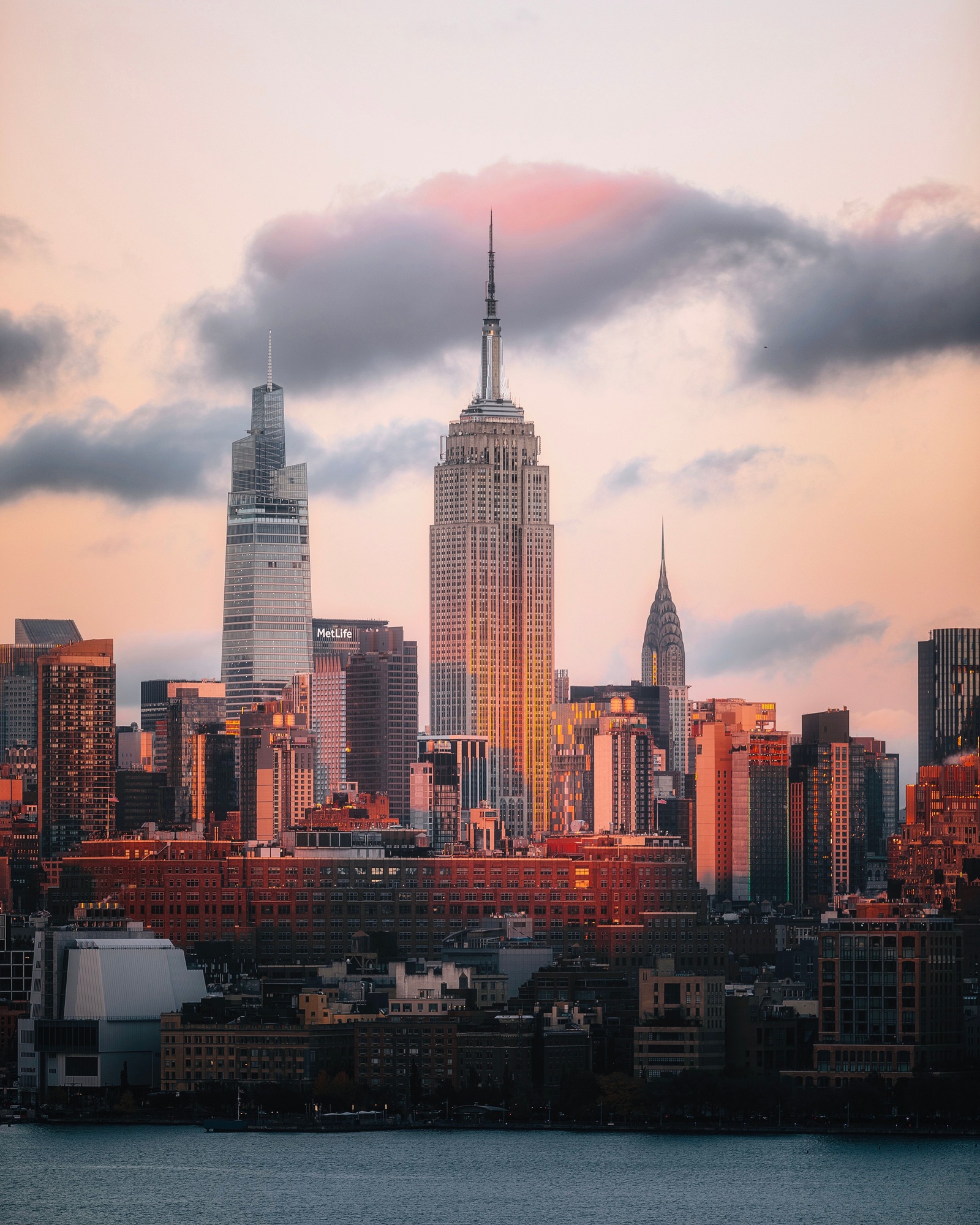 Beautiful view of the Empire State Building under a cloudy pink sky at sunset in New York City